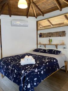 a bedroom with a bed with a blue comforter at Ginger Studio in Santa Teresa Beach