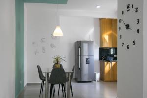 uma cozinha com uma mesa com cadeiras e um frigorífico em Sunset Apartment D em San Felipe de Puerto Plata