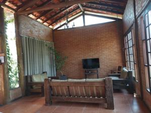 ein Wohnzimmer mit einem Sofa und einem TV in der Unterkunft Chácara 4 Ases J R in Cotia