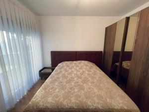 a small bedroom with a bed and a window at Apartment with balcony in Gjakove