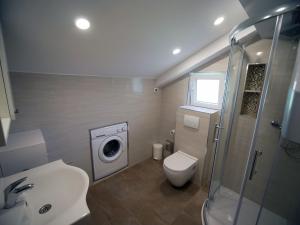 a bathroom with a toilet sink and a washing machine at Apartment Miho in Dubrovnik