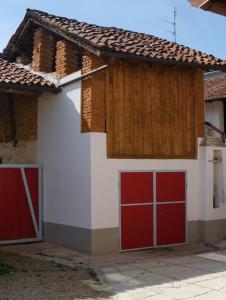 una casa con dos puertas de garaje rojas delante de ella en Maria's Bed - Intero alloggio accogliente, en Dorno