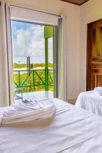 um quarto com uma cama e uma janela com vista em POUSADA CAJUEIRO em Santo Amaro