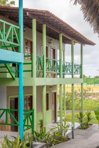 um edifício com colunas verdes e uma varanda em POUSADA CAJUEIRO em Santo Amaro