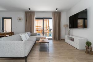 een woonkamer met een bank en een tv bij Villa A Lauda in Vrana