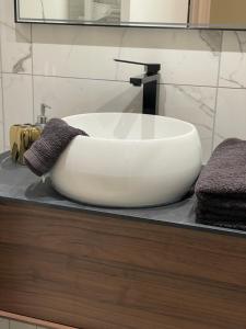 een witte wastafel op een aanrecht in een badkamer bij MC Suite CMZ* in Charleville-Mézières