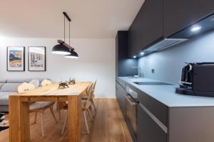 a kitchen and dining room with a wooden table at New! Cozy, central apartment with a stunning view in St. Moritz