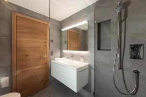 ein Bad mit einem Waschbecken und einer Dusche in der Unterkunft New! Cozy, central apartment with a stunning view in St. Moritz