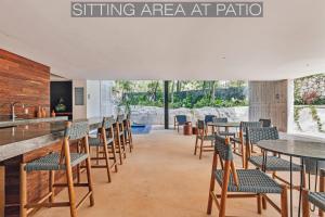 uma sala de jantar com mesas e cadeiras e uma cozinha em IIK Tulum Luxury Condo by Spot Rentals em Tulum