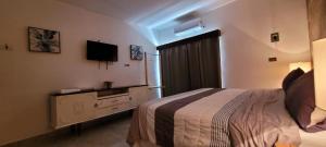 una camera d'albergo con letto e TV di Doña Adelina House a Ciudad Valles
