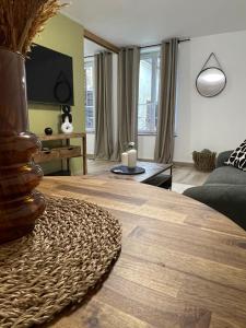 een woonkamer met een bank en een tafel bij MC Suite CMZ* in Charleville-Mézières