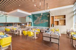 a dining room with tables and yellow chairs at Le Méridien Xi'an Chanba in Xi'an