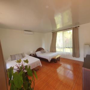 a room with two beds and a window at Lumbres Arenal in Fortuna