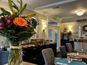 a vase filled with flowers sitting on a table at Anchor Inn Boutique Hotel in Put-in-Bay