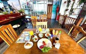 drewniany stół z talerzami jedzenia i napojów na nim w obiekcie PazZHOtel w mieście Valparaíso