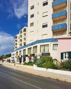 ein großes weißes Gebäude am Straßenrand in der Unterkunft Ericeira Vista Mar Peace and Sea in Ericeira