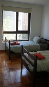 - 2 lits dans une chambre avec fenêtre dans l'établissement Stylish apartment dowtown 78m2, à Santiago