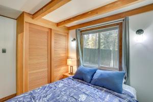 een slaapkamer met een bed en een groot raam bij Pet-Friendly Cabin with Fire Pit, Grill, and Trail! in Big Bear Lake