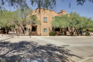 a building with trees in front of a street at Tucson Condo Rental with Balcony and Mountain View! in Tucson