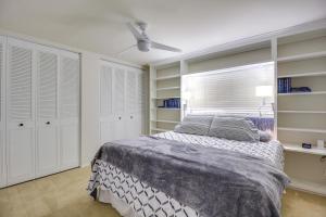 a bedroom with a bed with white cabinets and a window at Tucson Townhome with Shared Pool in 55 and Community! in Tucson
