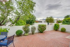 a patio with chairs and a white fence at Tucson Townhome with Shared Pool in 55 and Community! in Tucson