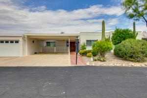 a large white house with a driveway at Tucson Townhome with Shared Pool in 55 and Community! in Tucson