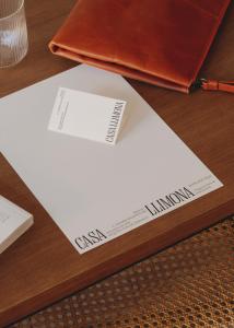 un papier blanc sur une table avec un portefeuille dans l'établissement Casa Llimona Hotel Boutique, à Barcelone