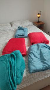 a bed with red and blue towels on it at Apartamento Novinho Aeroporto JF in Juiz de Fora +3 photos