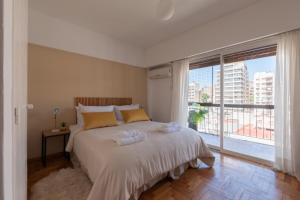 1 dormitorio con cama grande y ventana grande en Fliphaus Juncal 2800 - 2 Bd In Alto Palermo en Buenos Aires