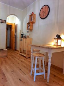 una habitación con una mesa y un reloj en la pared en [*Corazón*] il Loft del cuore en Filettino