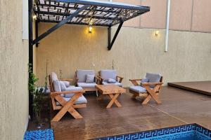 un patio con divani, tavoli e sedie di شالية بيهاتش a Al-Salam