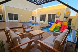 un soggiorno con piscina e area giochi di شالية بيهاتش a Al-Salam