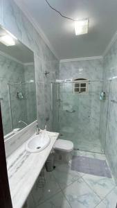 uma casa de banho com um chuveiro, um WC e um lavatório. em Chácara Marretto, ambiente acolhedor e familiar dentro da cidade de Tatuí. em Tatuí