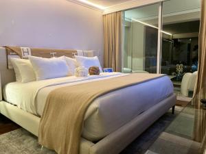 Un dormitorio con una cama grande con un osito de peluche. en Residence L´ Heritage Tennyson by BlueBay, en Ciudad de México
