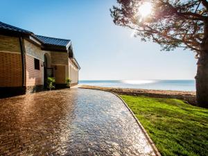 a cobblestone road next to a building and the ocean at Crona Hotel and SPA in Berdsk