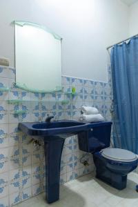 uma casa de banho com um lavatório azul e um WC. em “Casa W-J” Entire flat#1 /Doesn't flood. 2 garages em Guayaquil
