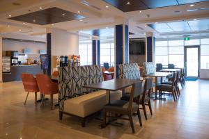 un restaurante con mesas y sillas en una habitación en Holiday Inn Express Kingston Central, an IHG Hotel, en Kingston