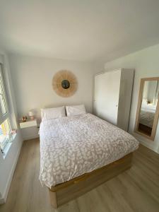 1 dormitorio con cama y espejo en la pared en Casa Rosa en Algarrobo-Costa