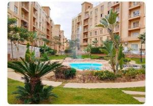 an apartment complex with a swimming pool and palm trees at A Wonderful Apartment in a compound in October Gardens in ‘Ezbet `Abd el-Ḥamîd +39 photos