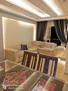 a living room with a couch and two chairs at A Wonderful Apartment in a compound in October Gardens in ‘Ezbet `Abd el-Ḥamîd