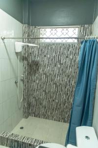 uma casa de banho com um chuveiro com uma cortina de chuveiro azul em “Casa W-J” Entire flat#1 /Doesn't flood. 2 garages em Guayaquil