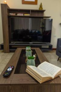 a coffee table with an open book and a remote control at “Casa W-J” Entire flat#1 /Doesn't flood. 2 garages in Guayaquil