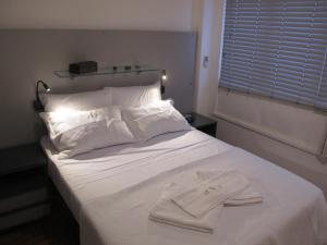 a white bed with a white towel on it at Apartamento quarto e sala in Rio de Janeiro