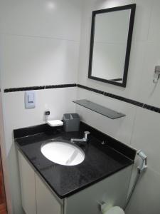 a bathroom with a sink and a mirror at Apartamento quarto e sala in Rio de Janeiro