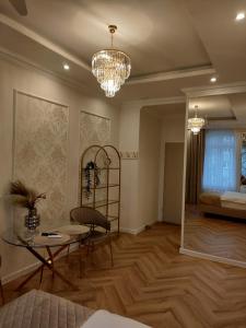 ein Wohnzimmer mit einem Kronleuchter, einem Tisch und einem Bett in der Unterkunft Crystal in Zielona Góra