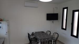 uma sala de jantar com uma mesa e cadeiras e uma televisão em Casa Costa Sur em Posadas
