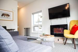 a living room with a couch and a tv at Reved Up & Out - Remarkable Two Bedroom Condo in Revelstoke
