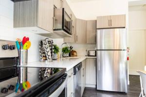 a kitchen with a stainless steel refrigerator and cabinets at Reved Up & Out - Remarkable Two Bedroom Condo in Revelstoke