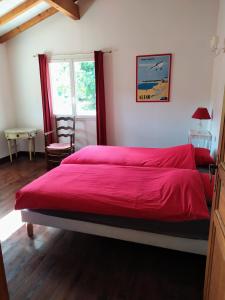 1 dormitorio con 1 cama grande con sábanas rojas y ventana en XOKO GORRI, en Urrugne