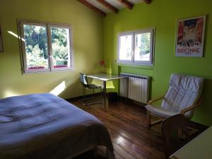 1 dormitorio con 1 cama, 1 mesa y 1 silla en XOKO GORRI, en Urrugne
